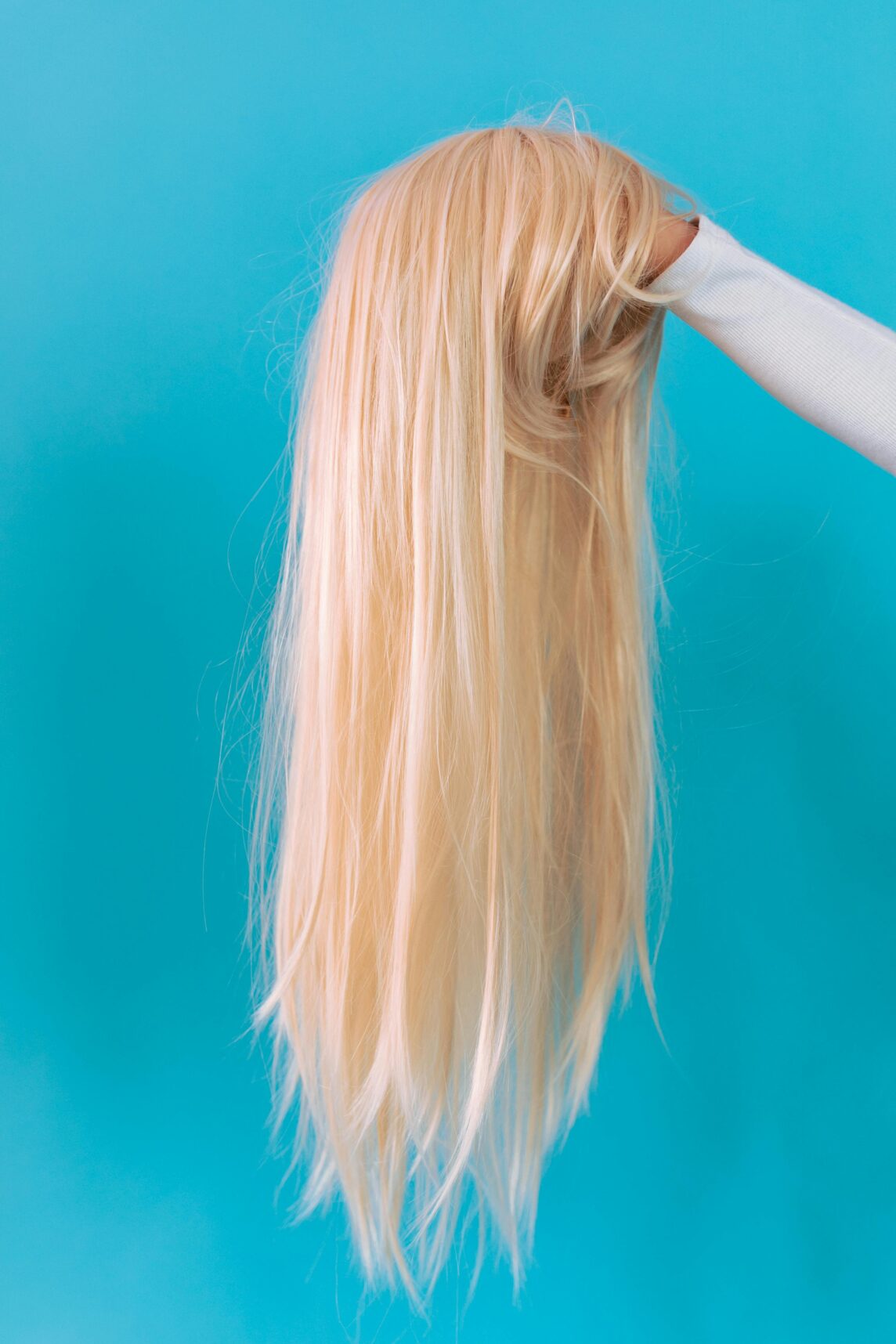 Client browsing salon display to buy hair extensions made from natural human hair.